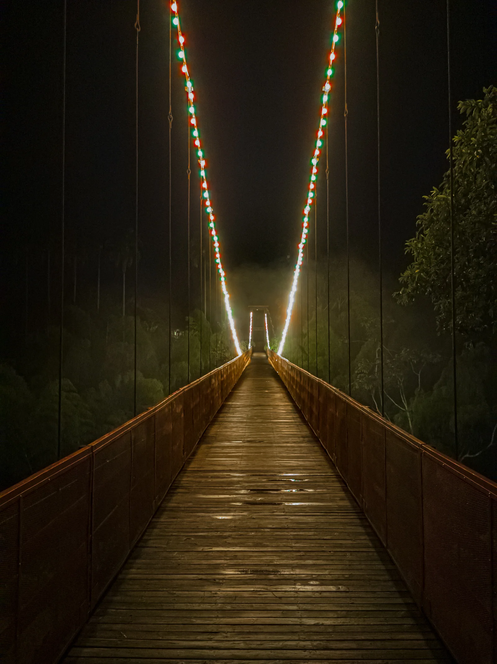 Beleuchtete Brücke zwischen PANACA und dem Hotel bei Nacht