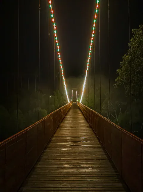 Beleuchtete Brücke zwischen PANACA und dem Hotel bei Nacht