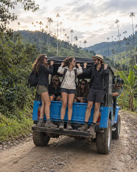 Reisende stehen hinten auf einem blauen Willys, Wachspalmen von Cocora